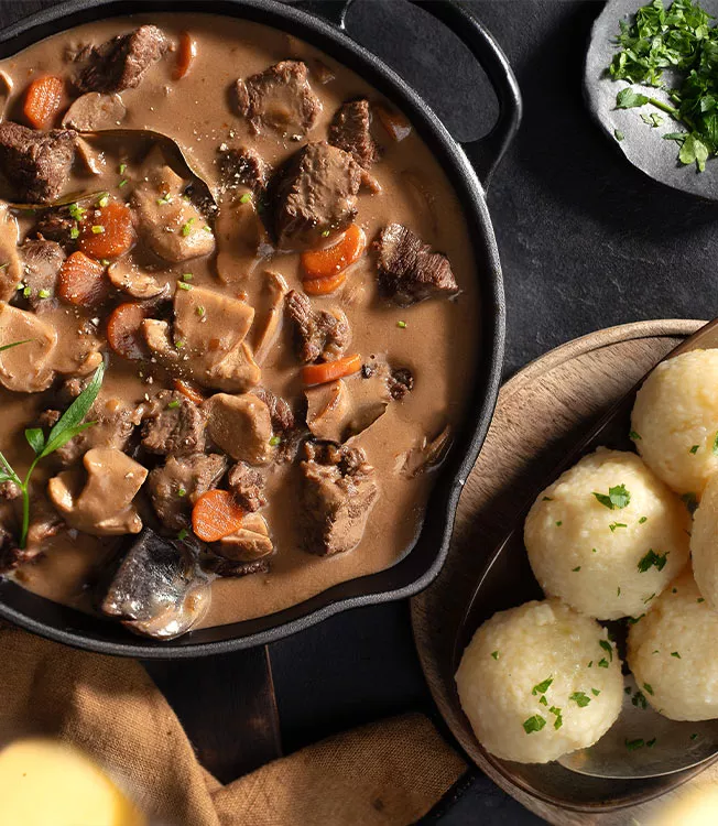 Sappige hertenstoofpot met paddenstoelen en aardappelknoedels