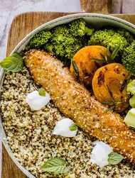 Bowl met warme quinoa en met sesam bedekte zalm en abrikozen