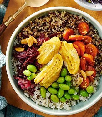 Warme rijst en quinoa bowl met omelet en pinda's